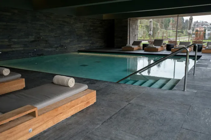 A calm indoor spa pool with loungers